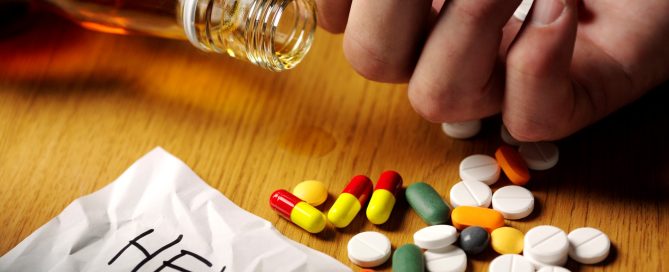 A hand reaching toward scattered prescription pills beside an open pill bottle on a wooden surface, with a paper labeled “HELP” nearby.