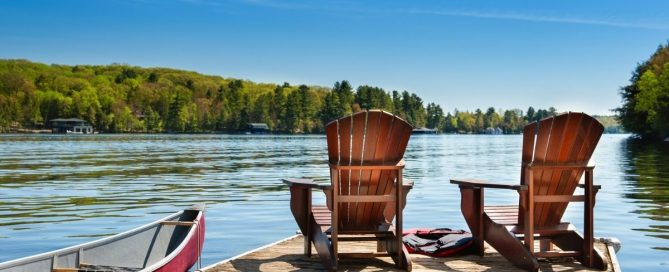 Peaceful lakeside dock with two chairs and a canoe representing reflection, healing, and long-term recovery from compulsive sexual behaviour.