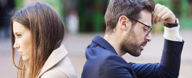 Couple sitting back to back showing emotional distance after discovery of sex or porn addiction